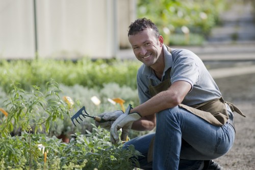 Close-up of a gardener's hands planting seeds in an accessible raised bed.
